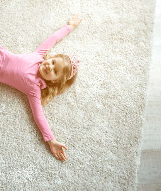 Cute girl laying on rug | Bodamer Brothers Flooring