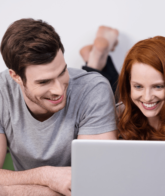Happy couple with laptop | Bodamer Brothers Flooring